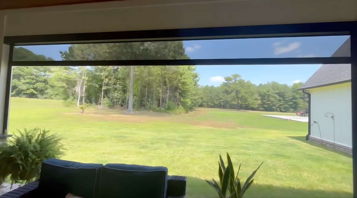 Motorized shades on large windows for energy efficiency and privacy.