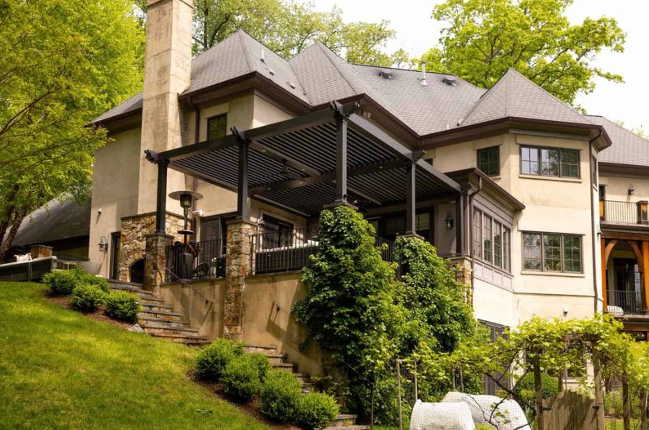 Custom outdoor deck with pergola and lush landscaping.