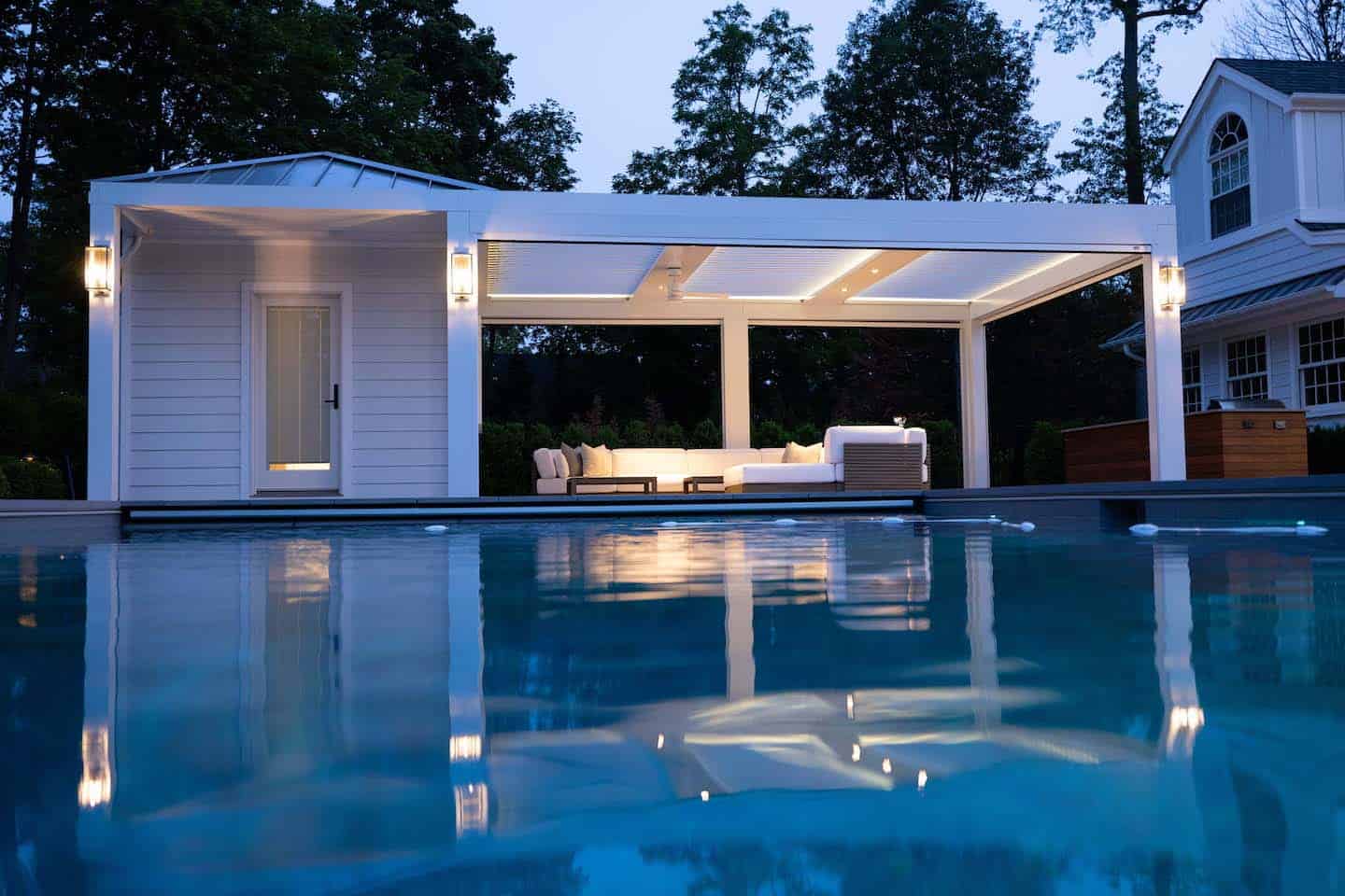 Pergola with outdoor seating by the pool for relaxing and entertaining.